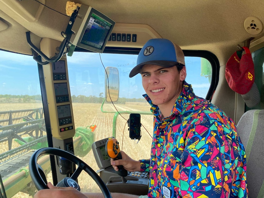 A teenage boy wearing a colourful shirt smiling in a header cabin.