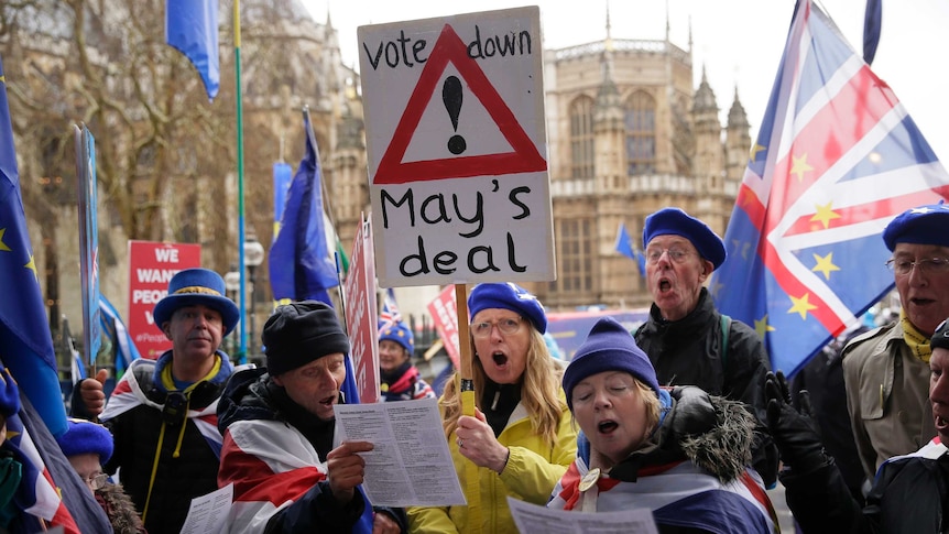 Anti-Brexit voters holding placards and singing outside the House of Parliament in London.