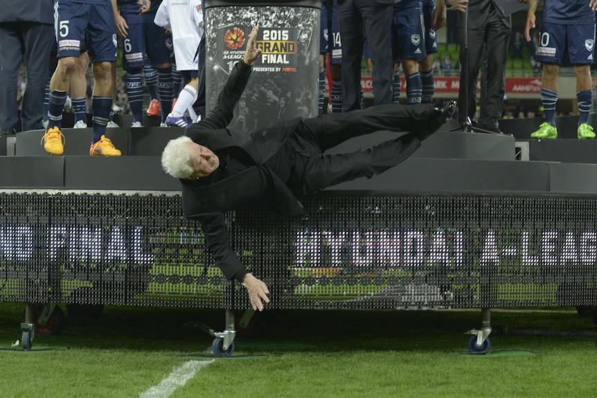 FFA chairman Frank Lowy falls off the stage at the A-League grand final at AAMI Park.