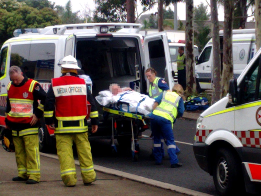Paramedics place one of the residents of the Quakers Hill Nursing Home into an ambulance.