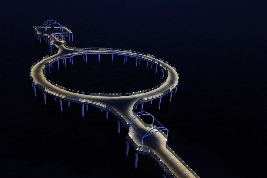 An artist's depiction of the jetty with a loop in the middle at night with LED lights around the structure turned on.