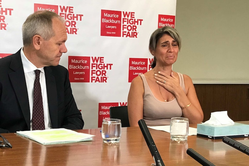 Lawyer Ben Slade sits next to Michelle Tate at a press conference.