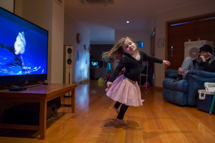 Jayde dances in the lounge room while watching Frozen.