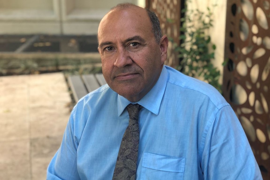 Headshot of Richard Weston wearing a blue shirt and tie.