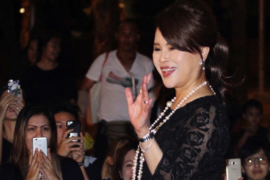 Thai Princess Ubolratana Mahidol wearing a black lace dress and pearls waves to Thai people outside Grand Palace in Bangkok.