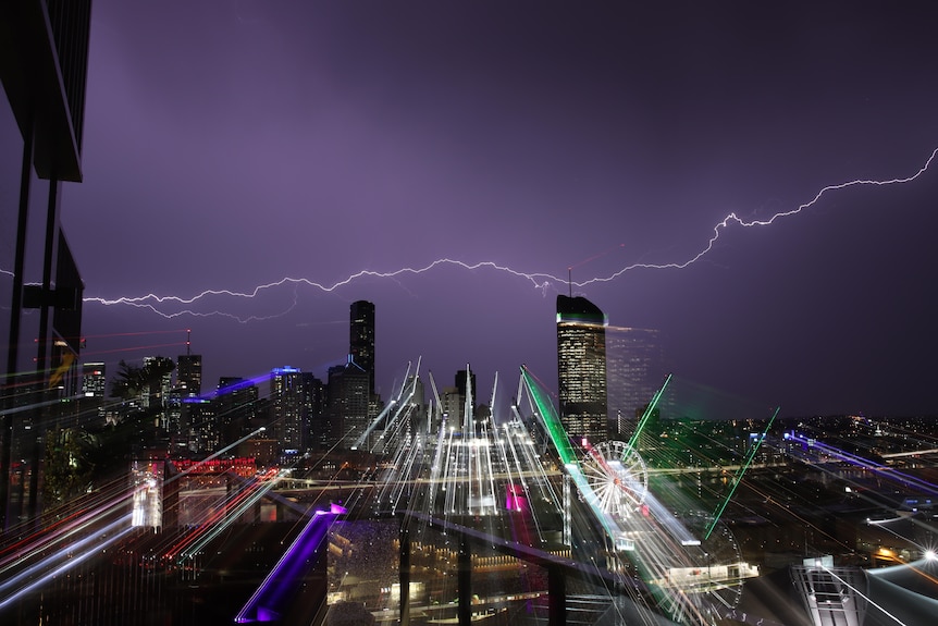 A long streak of lightning horizontal across the Brisbane sky, with the night appearing purple.