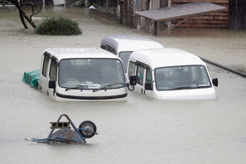 Cars sit submerged in water in the residential area hit by Typhoon Hagibis, in Ise, central Japan.
