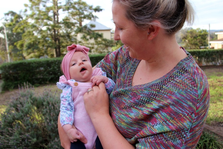 A woman looks lovingly at her baby girl.