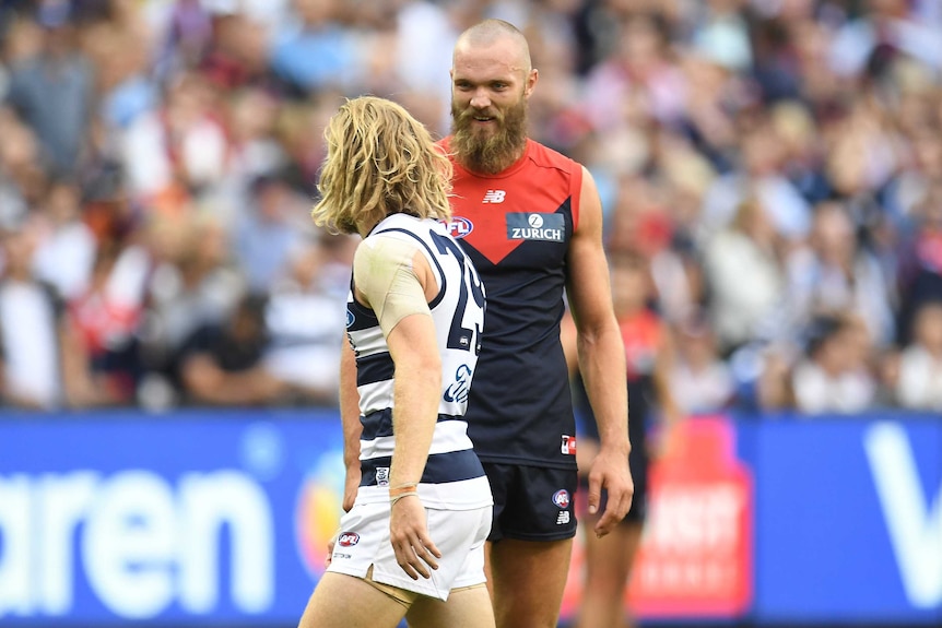 Max Gawn (R) and Cameron Guthrie exchange words after the final siren in the Cats' round one win over the Demons.
