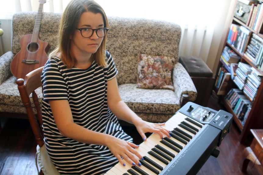 Perth soprano Bri Louwen sits at her keyboard.
