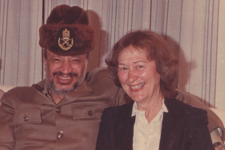 Janet Venn Brown sits on a couch with Yasser Arafat