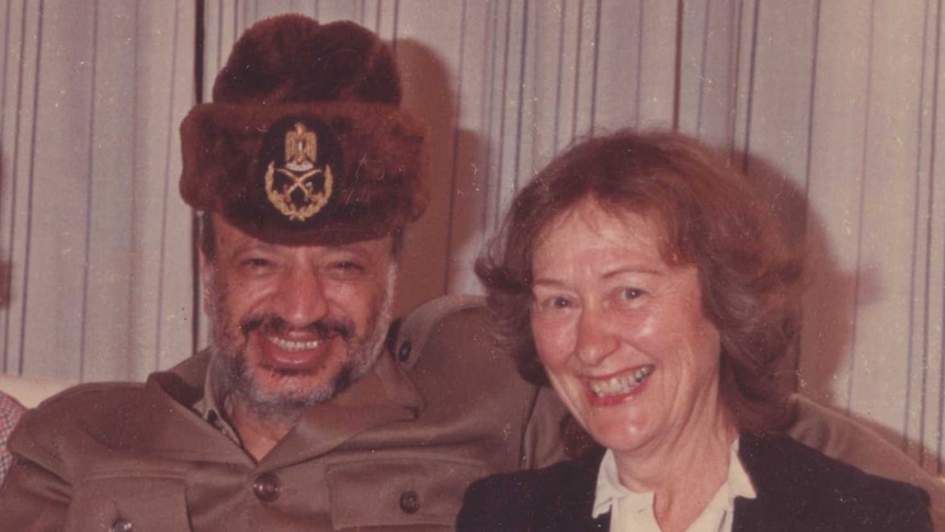 Janet Venn Brown sits on a couch with Yasser Arafat