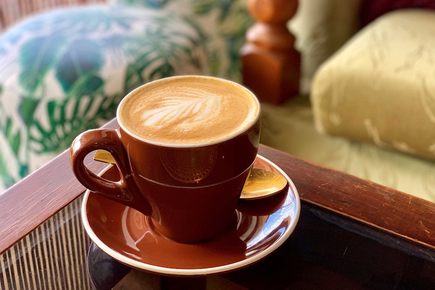 A coffee cup sits on a table in a cafe