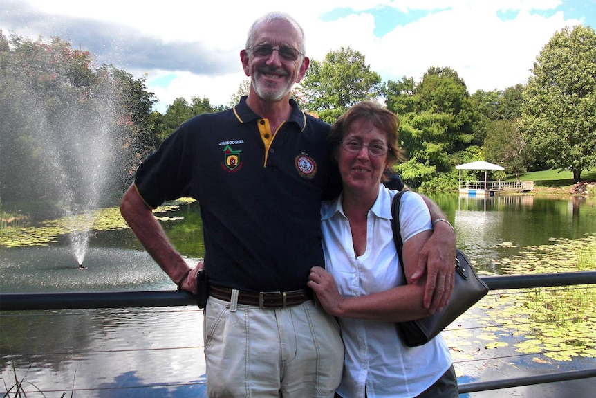 Alan with his wife Mal standing in front of a pond in a park