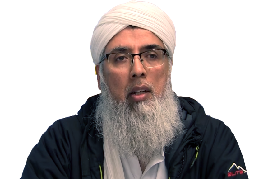 A man with a beard, glasses and Islamic head wear. 