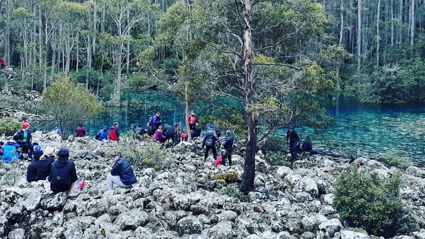 People gathered at mountain tarn.