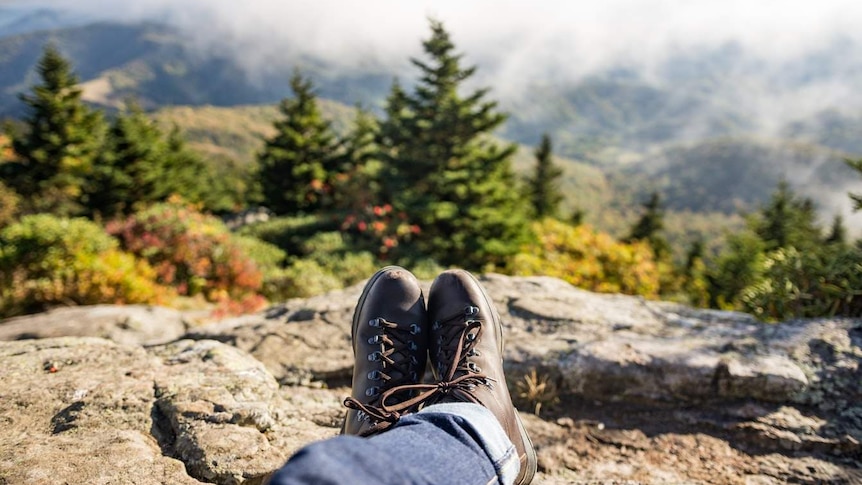 A person's legs are crossed as they relax in a scenic environment