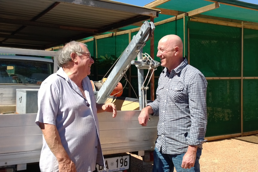 Two men in front of a ute in Coober Pedy.