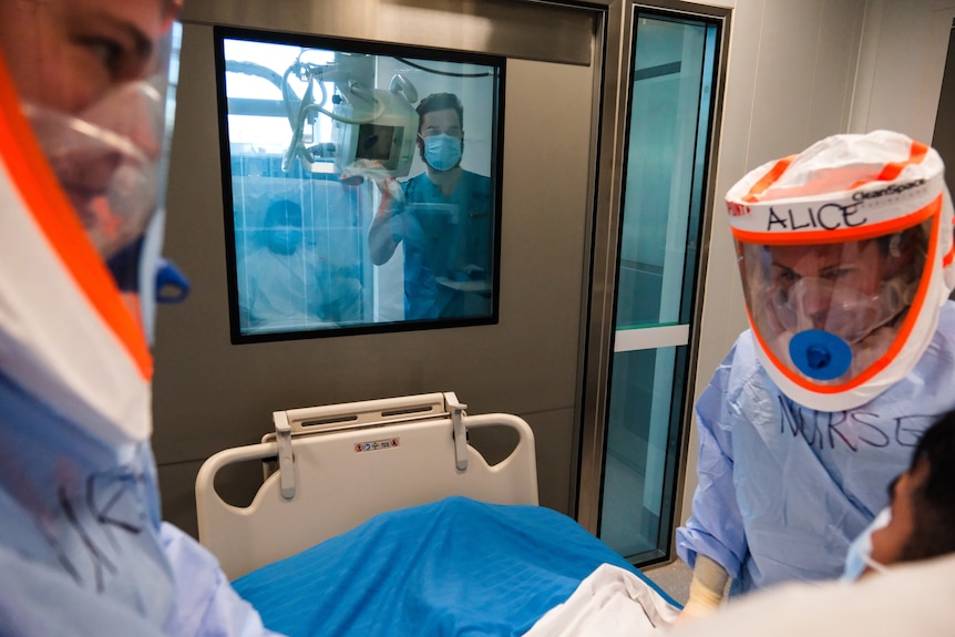 health care workers dressed in protective clothing look after a highly infectious patient