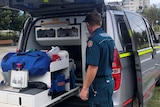 Paramedic man stands in front of the van used to respond to mental health crises calls 