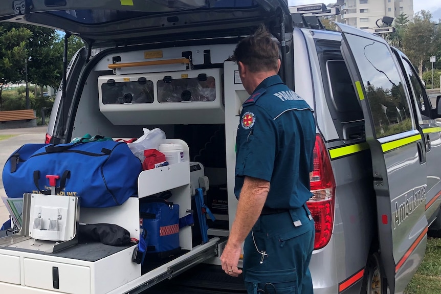 Paramedic man stands in front of the van used to respond to mental health crises calls 