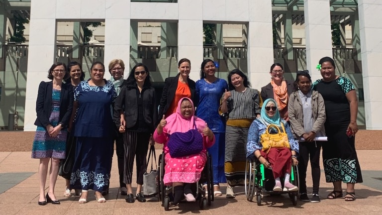 Group of people in front of the Australian Parliament.