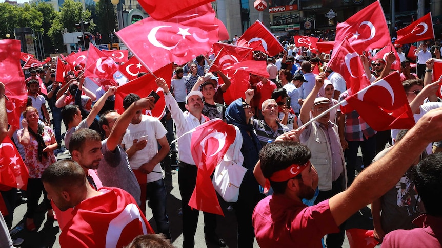 People wave national flags on the streets of Ankara.