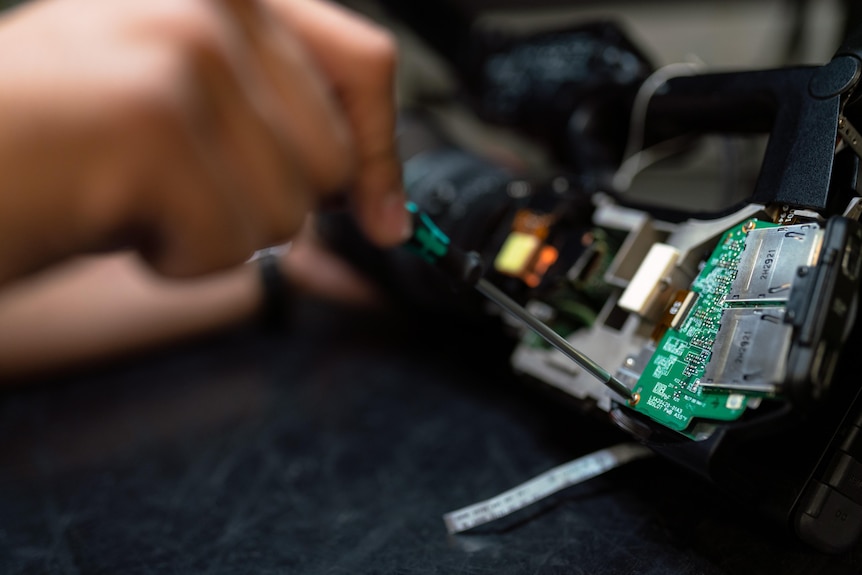 Hand with screwdriver on microchip