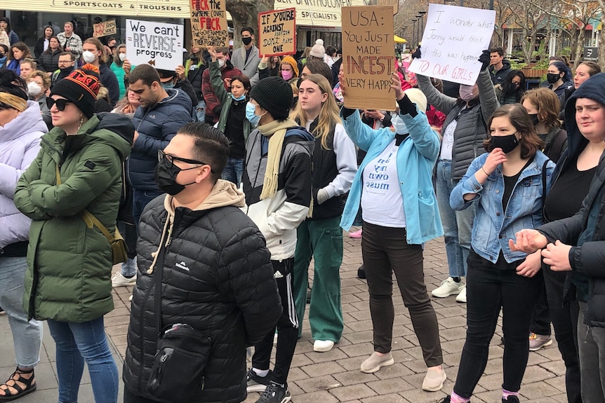 Protesters holding signs and walking.