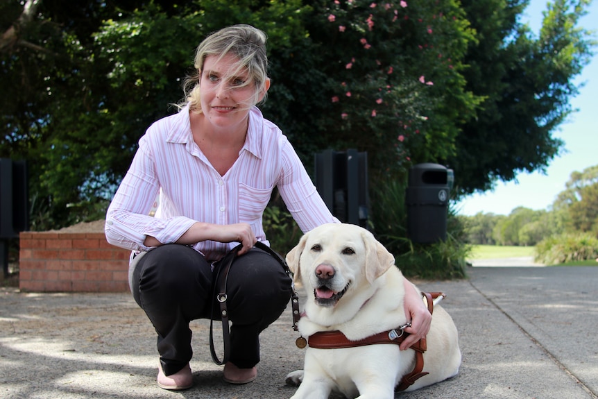 Kimberlee Brooker sits with her guide dog Toffee at the Port Kembla Golf Club.