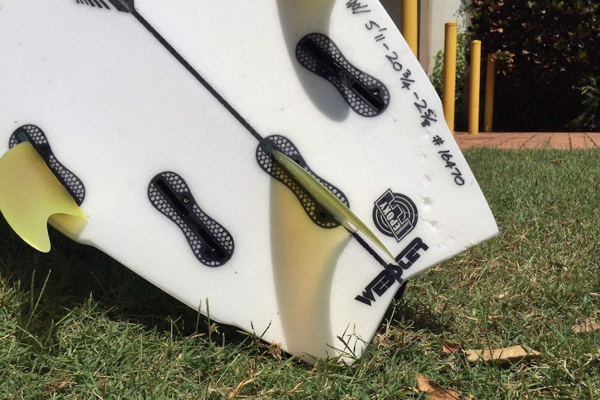 A surf board with bite marks on the end