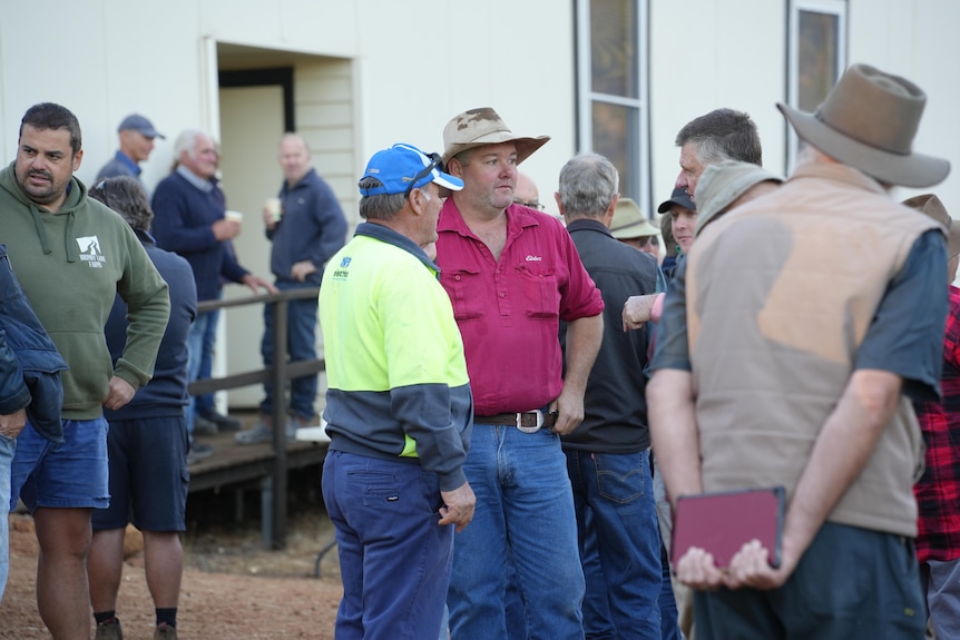 A group of farmers speak outside the meeting in Yornup.
