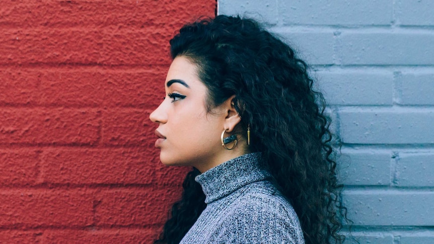 A woman standing in front of a red and blue wall.