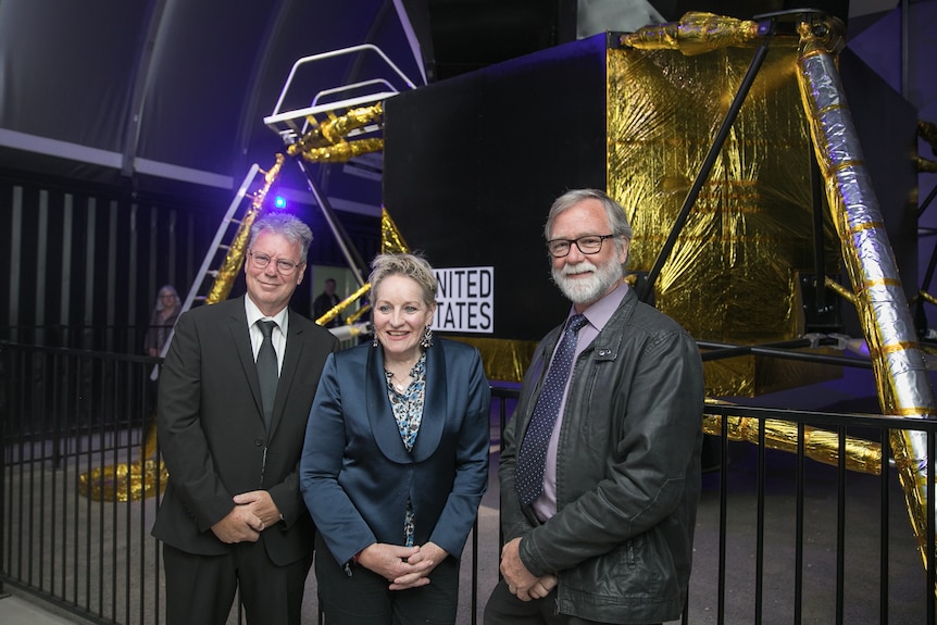 Phil Youd, Regional Development Minister Alannah MacTiernan and Denham Dunstall standing in front of the lunar lander replica. 