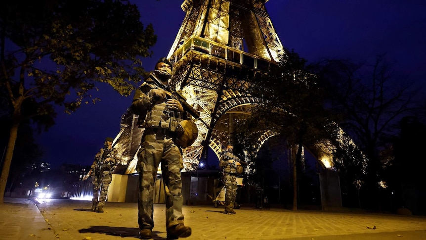 French ground army soldiers of the Sentinelle force patrol next to the Eiffel Tower in Paris.