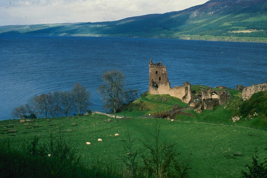 The ruins of a castle sit at the edge of Loch Ness