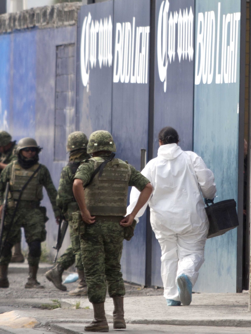 Members of the Mexican Army and forensic personnel arrive at the place where gunmen stormed a beer hall killing 10 people.