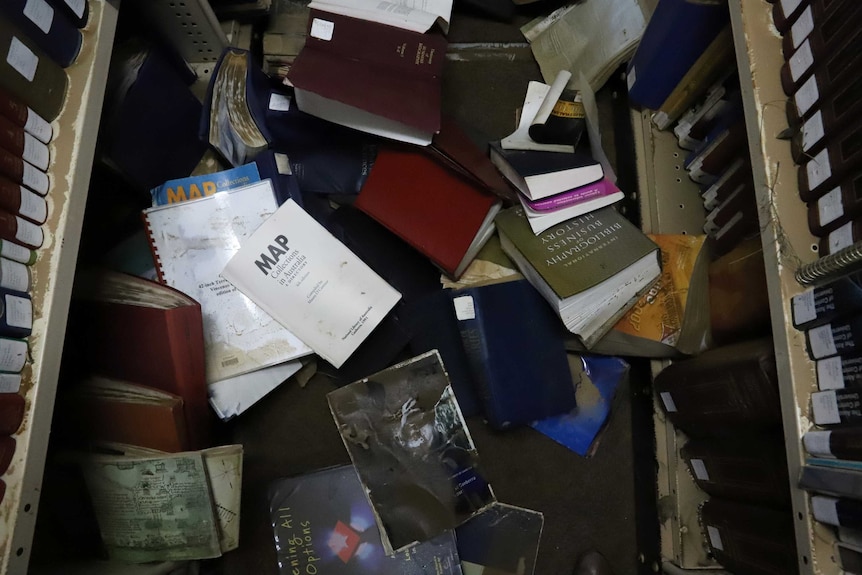 Damaged books on the floor of a library.