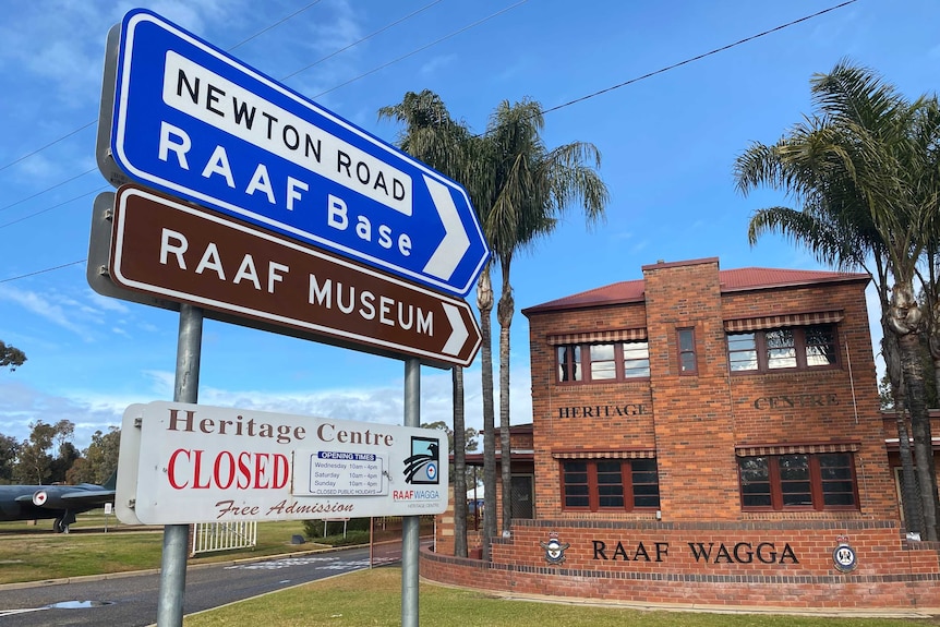 A sign saying RAAF base and RAAF Museum pointing towards a brick building.