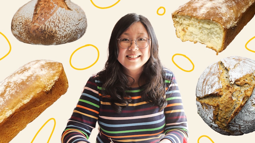 Smiling woman surrounded by different types of bread loaves, from sourdough to homemade white loaf.
