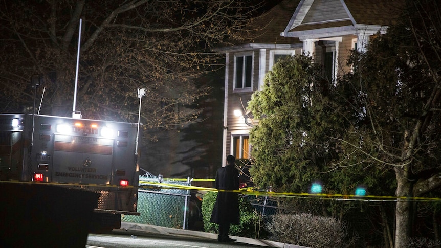 At night, you view a lone Orthodox Jewish man behind police tape between a Jewish ambulance and a house.