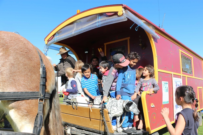 Kids on board a wagon driven by Harry Vidal, on his way to Lightning Ridge to raise money for charity.