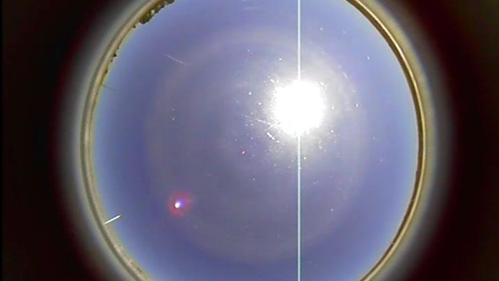 A small bright dot in the sky next to the sun, captured be a resident's sky cam.