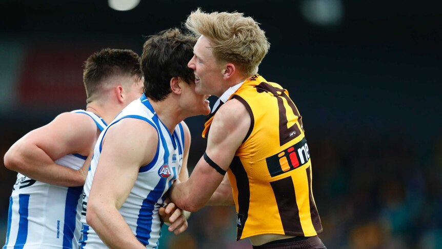 James Sicily holds onto the jumper of Jy Simkin during an altercation.