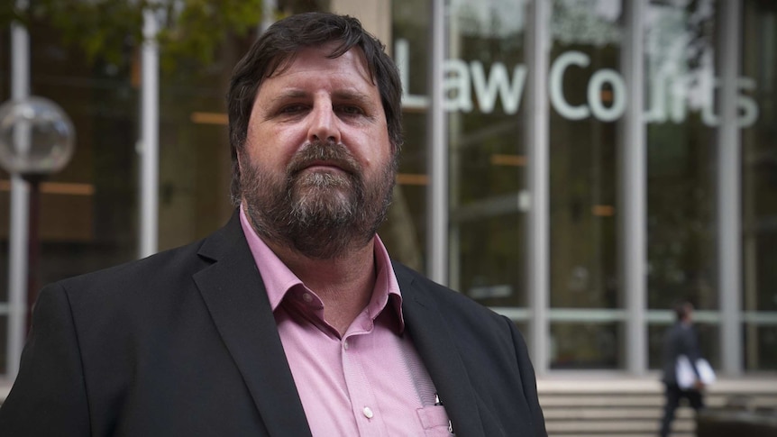 A man in front of the NSW Law Courts.