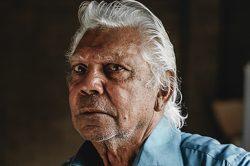 Studio portrait of an older Aboriginal man.