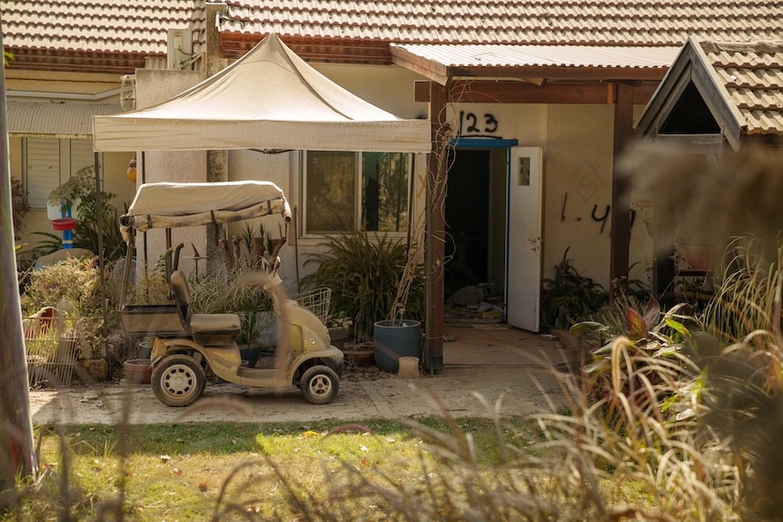 A small house with a golf cart out the front. 