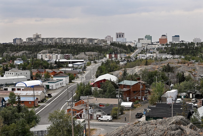 Вид сверху на улицу города, окруженную зданиями.