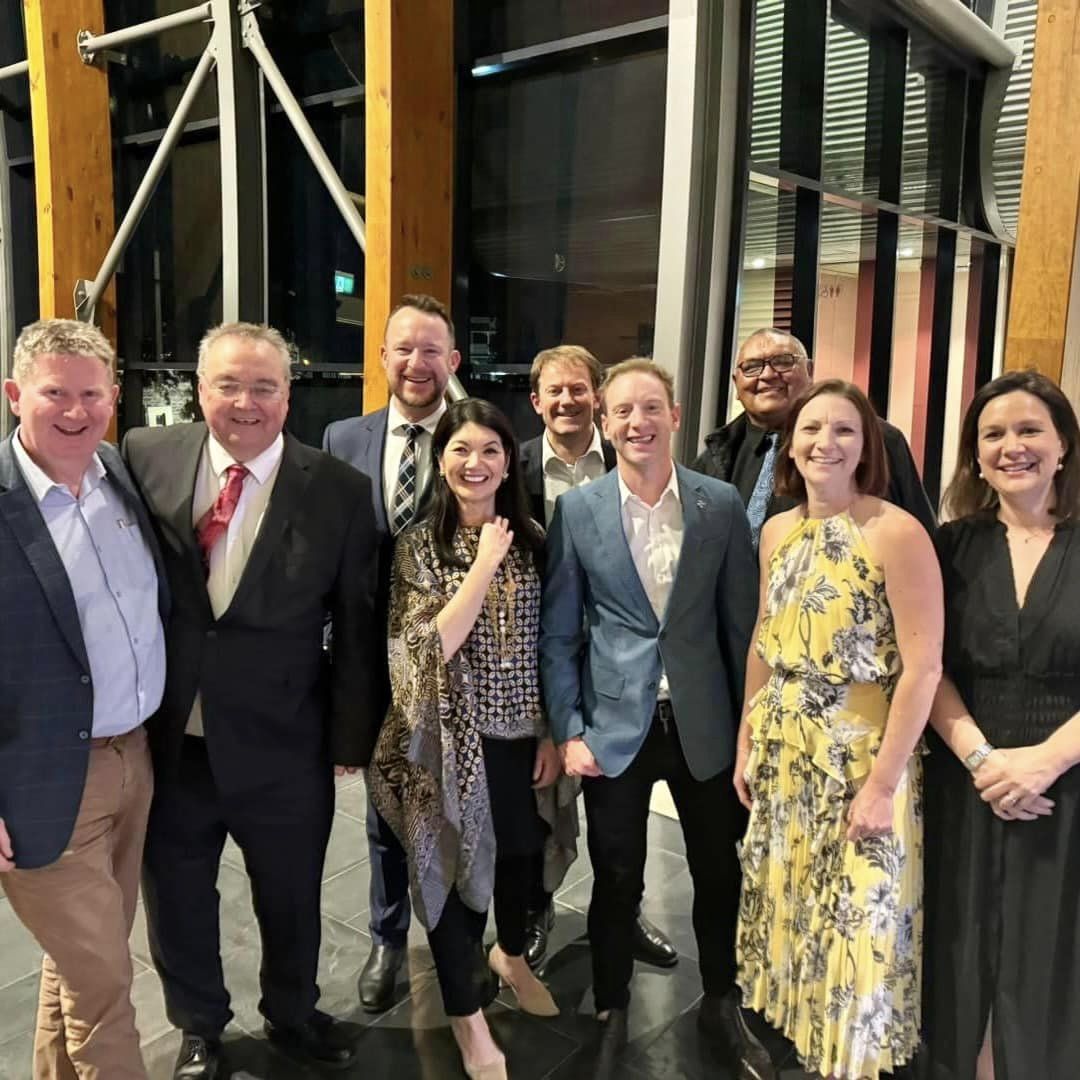 A group of people posing for a photo at a dinner. 