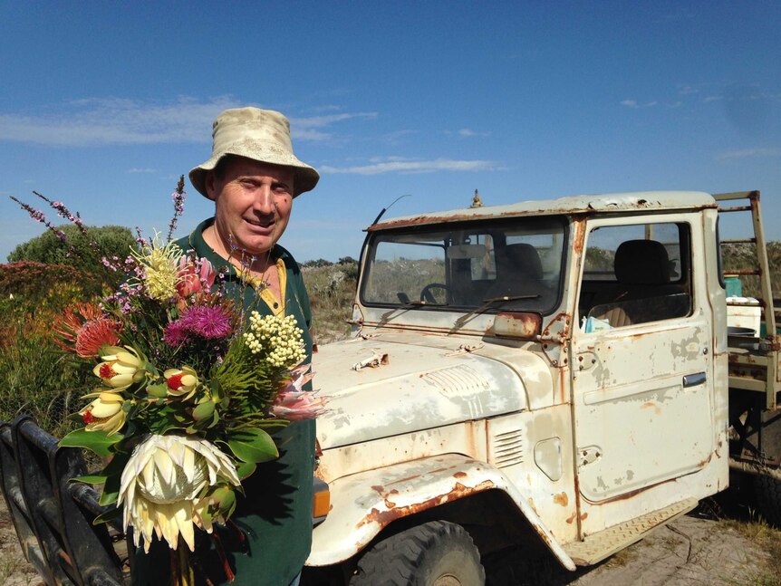 Miga Lake shearer Brett McDonald holding a bunch of the flowers he grows on his farm